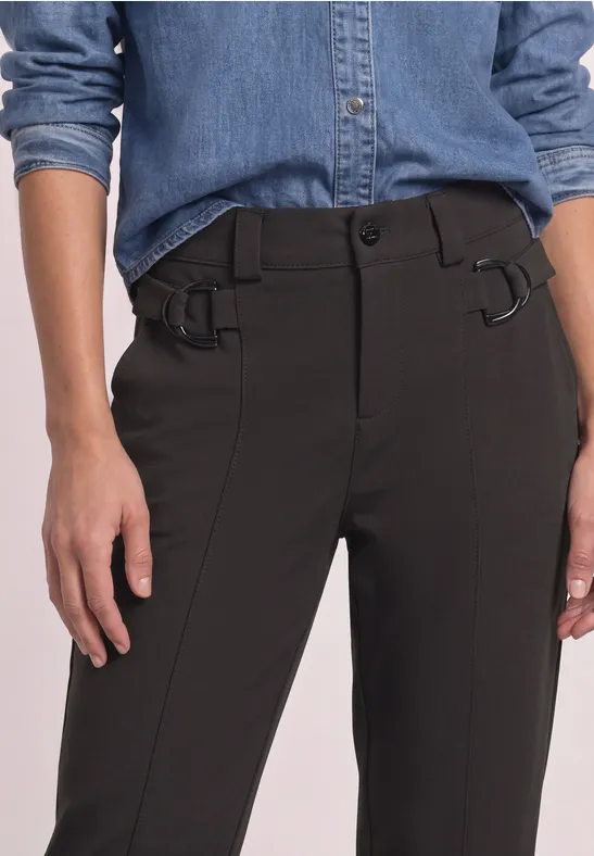 Person trägt schwarze Hose mit Gürtelschlaufen und Schnallen sowie hellblaues Jeanshemd.
