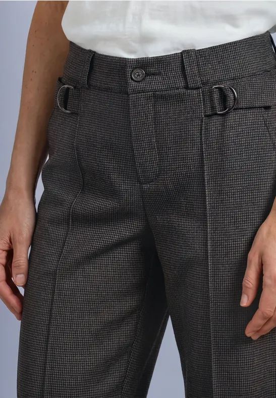 Person trägt braune Wollhose mit seitlichen Schnallen und ein weißes Hemd.