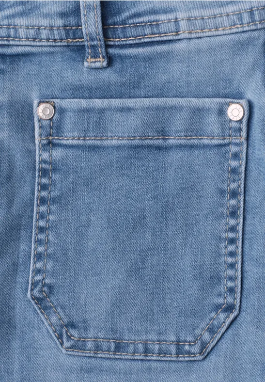 Close-up van een blauwe jeans met zichtbare zak en stiksel.