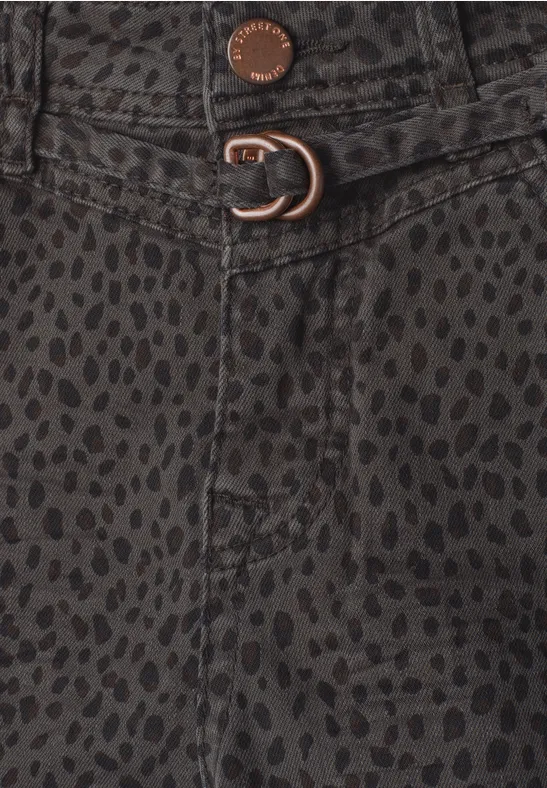 Nahaufnahme eines dunkelgrünen, gepunkteten Stoffes mit Metallknopf und D-Ring-Verschluss