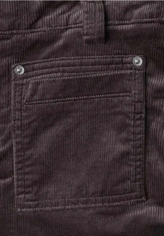 Braune Cordhose mit aufgesetzter Tasche und Metallösen, Nahaufnahme.