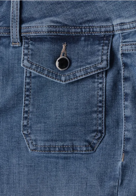Close-up auf eine blaue Jeans mit kleiner Klappentasche und Knopf.