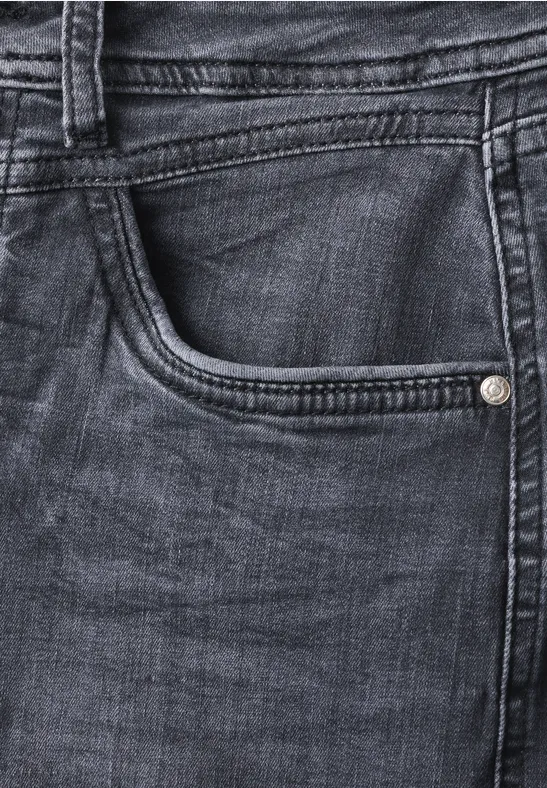 Nahaufnahme einer blauen Jeanshose mit sichtbarer Tasche, Gürtelschlaufe und Nahtdetails.