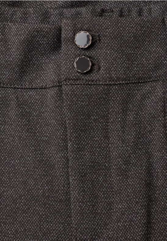 Gros plan d’un pantalon sombre en tissu avec deux boutons visibles à la taille.
