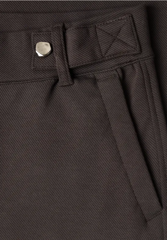 Nahaufnahme einer dunkelbraunen Hose mit Gürtelschlaufe, Taschenöffnung und Nähten.