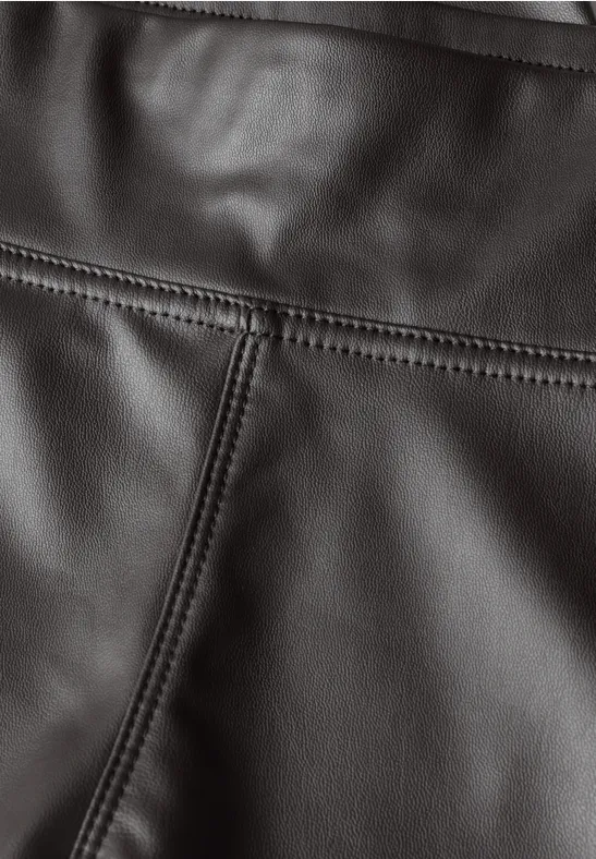 Nahaufnahme von schwarzem Leder mit akkuraten Nähten und sichtbarer Textur.