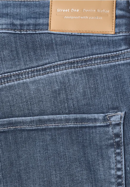 Nahaufnahme einer blauen Jeans mit Gesäßstasche und Lederpatch 'Street One'.