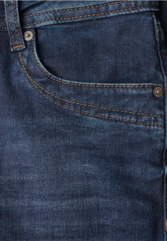 Nahaufnahme einer blauen Jeans mit sichtbarer Tasche, Nahtdetails und Metallnieten.
