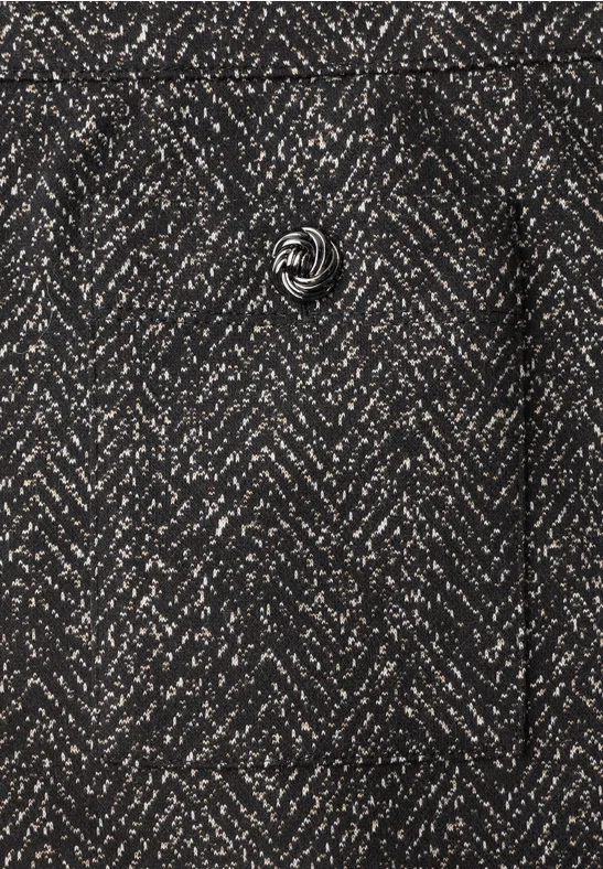 Nahaufnahme eines anthrazitgrauen Herringbone-Mantels mit feinem Fischgrätmuster und rundem Knopf.