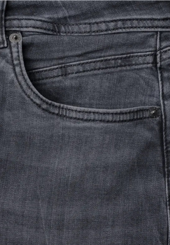 Nahaufnahme einer dunklen Jeanshosentasche mit Naht und Münztasche.