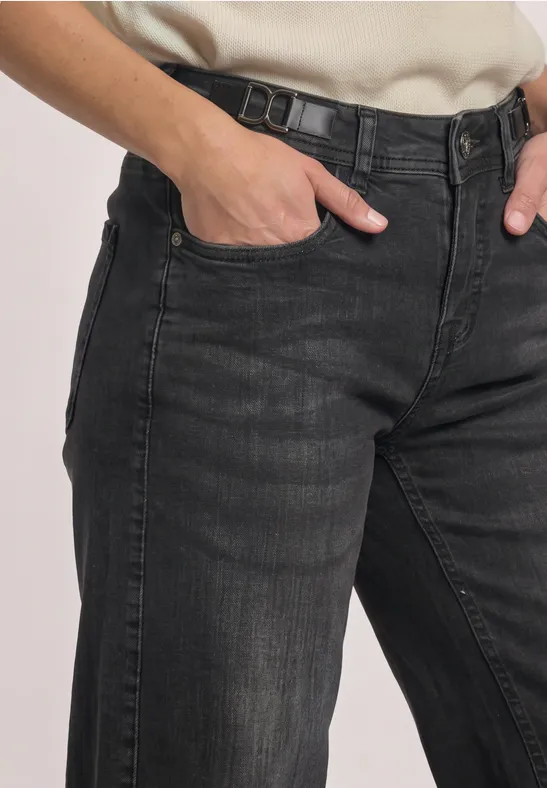 Schwarzgraue Jeans mit Hand in der Hosentasche, klare Nähte und dezentes Used-Finish.