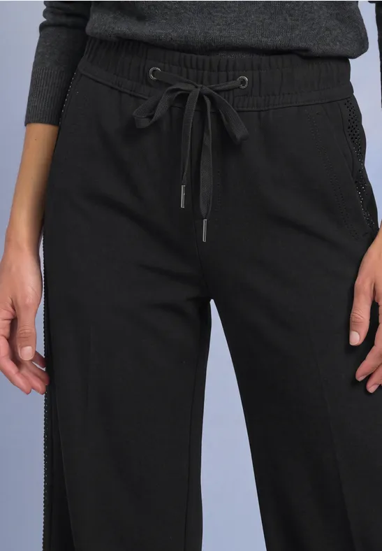 Zwarte, losse broek met wijd broekspijp en taillekoord.