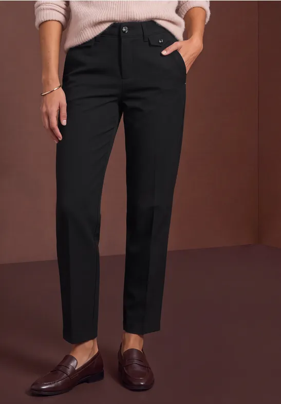 Schwarze, knöchellange Hose mit geradem Schnitt, kombiniert mit braunen Loafern.