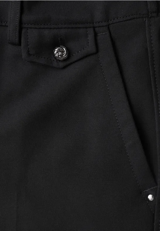 Detail einer schwarzen Tasche mit Klappe, silbernem Druckknopf und kleiner Niete.