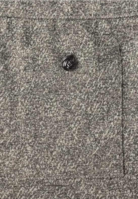 Nahaufnahme eines grauen Wollstoffs mit einem schwarzen, geriffelten Knopf.