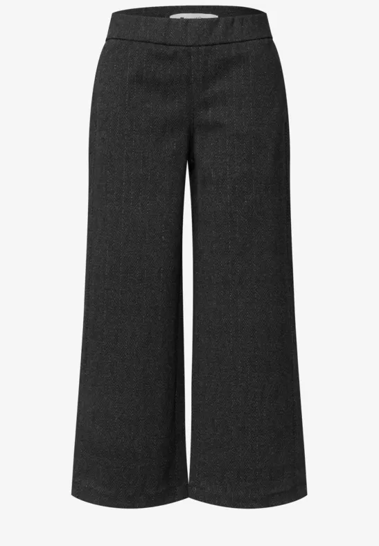 Pantalon noir taille haute, coupe ample à jambe large.