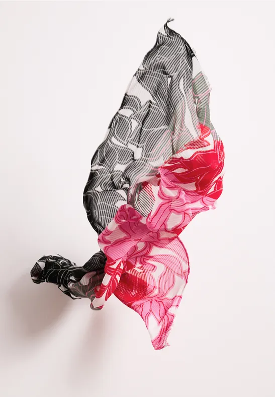 Unoszący się materiał z kwiatowym wzorem w czerni, bieli i intensywnej czerwieni na białym tle.