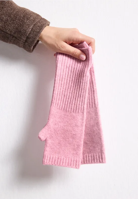 Eine Hand hält rosa, gestrickte, fingerlose Handstulpen.