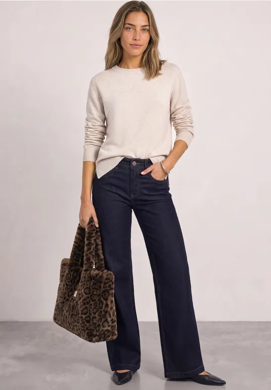 Frau im hellen Pullover und weiten, dunklen Hosen mit Leoparden-Shopper