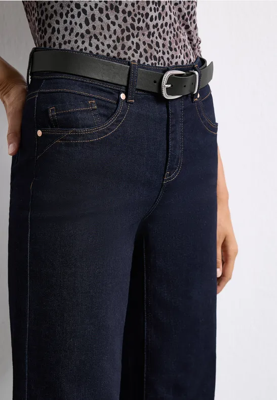 Dunkelblaue Jeans mit schmaler Passform, kombiniert mit einem schwarzen Gürtel vor weißem Hintergrund.
