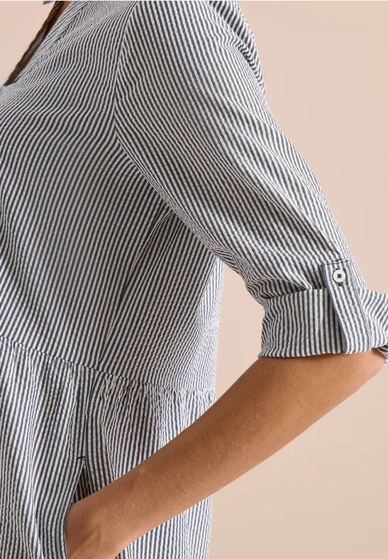 Seitliche Ansicht eines Oberkörpers in einem weiß-blau gestreiften Hemd mit 3/4-Ärmeln