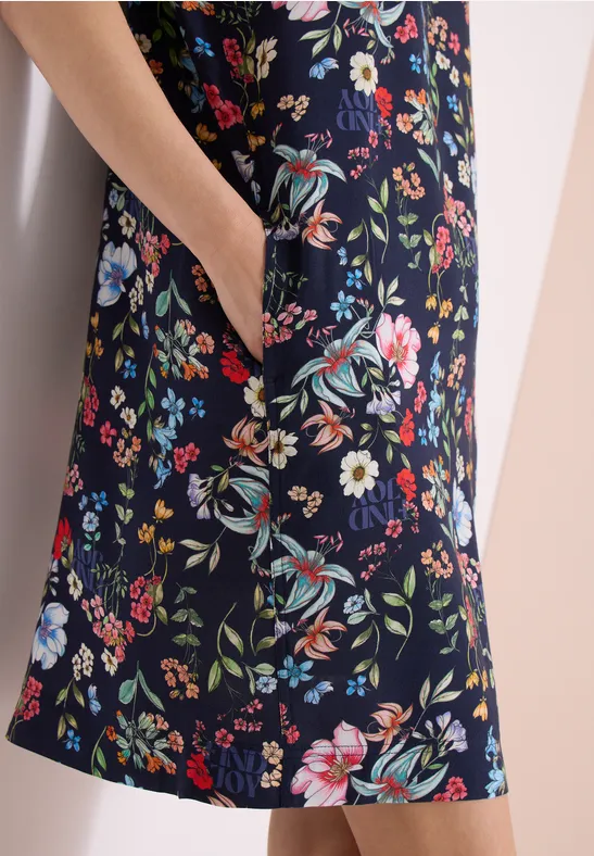 Dunkelblaues Kleid mit buntem Blumenmuster, seitliche Tasche, Nahaufnahme.
