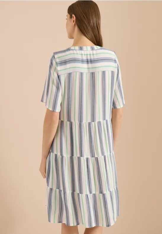 Ein pastellgestreiftes Midikleid mit kurzen Ärmeln und Stufen, Rückansicht vor neutralem Hintergrund.