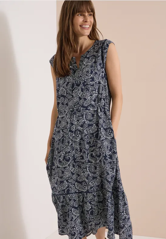 Femme portant une robe longue sans manches à motif cachemire bleu et blanc.