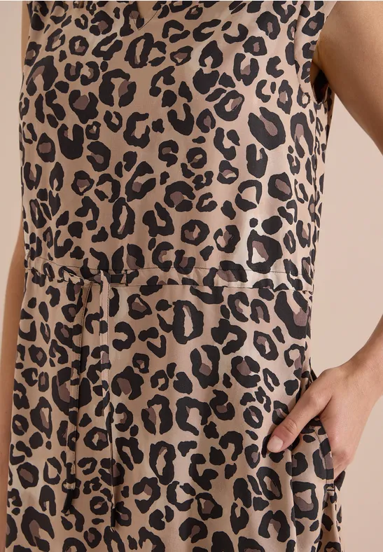 Nahaufnahme eines ärmellosen Kleides mit beige-schwarzem Leopardenmuster, Taillenbindung und seitlicher Tasche.