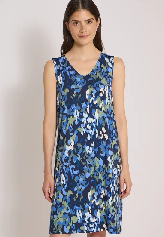 Eine Frau trägt ein ärmelloses, knielanges A-Linien-Kleid mit blau-grünem abstraktem Blumenmuster.