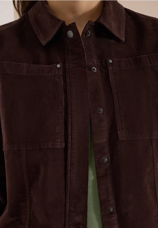 Dunkelbraune Cordjacke mit Taschen und Knopfleiste, grünes Shirt schimmert darunter.