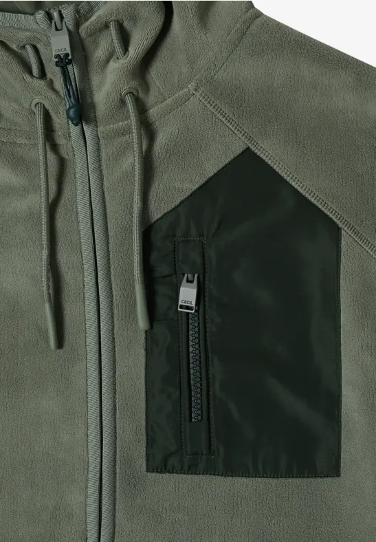 Grüne Softshell-Jacke mit Kapuze, Reißverschluss und dunkler Brusttasche.