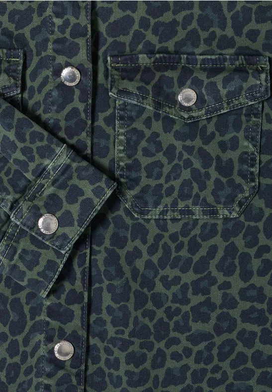 Grüne Hemdjacke mit schwarzem Leopardenmuster, aufgesetzter Brusttasche und silbernen Druckknöpfen.