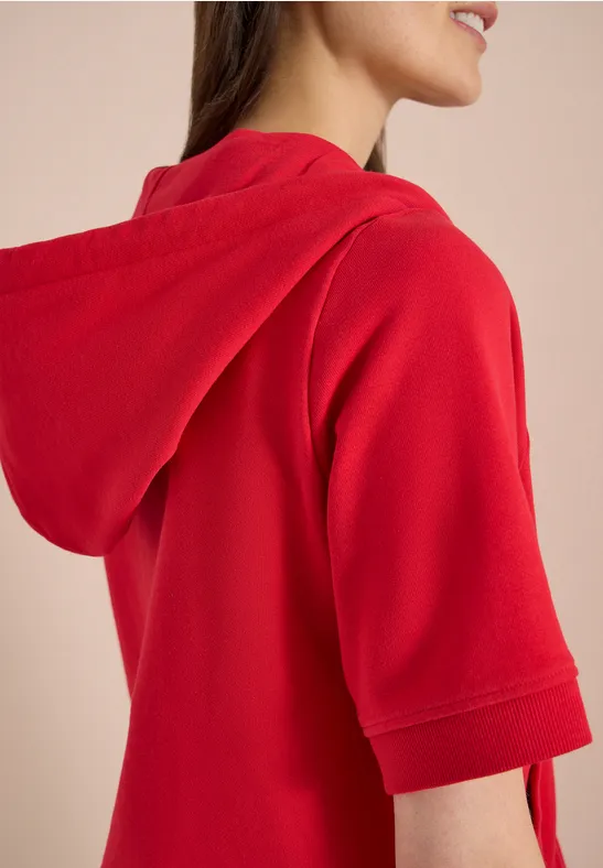 Seitliche Ansicht eines roten Kurzarm-Hoodies auf einer Person