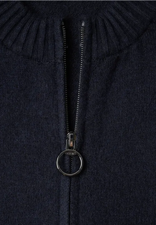 Nahaufnahme eines dunkelblauen Strickpullovers mit Reißverschluss und rundem Reißverschlussanhänger