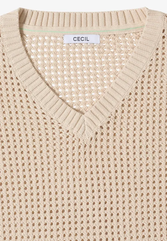 Pull en maille beige plié, col en V et motif ajouré, étiquette "CECIL" au niveau du col.