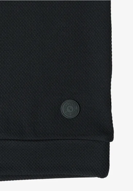 Tissu noir texturé avec petit logo circulaire cousu au bord
