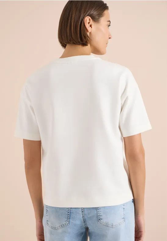 Personne vue de dos portant un t-shirt blanc uni et un jean bleu.