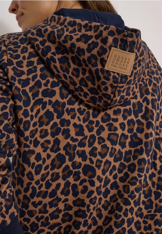Vue arrière d'une veste à capuche marron à motif léopard noir, ornée d'un écusson en cuir.