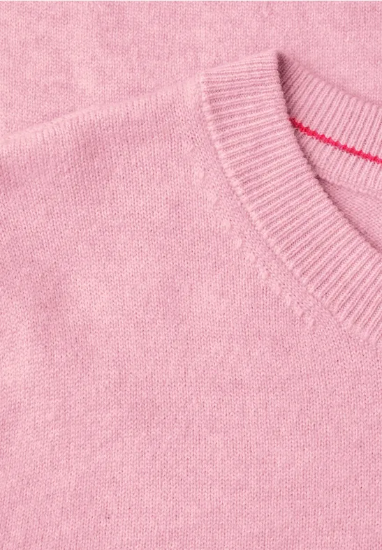 Un pull rose en maille fine et douce.