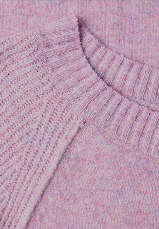 Gros plan sur un pull rose-lilas en tricot avec encolure ronde.