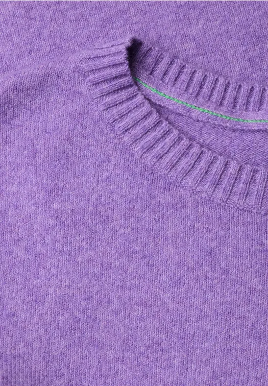 Gros plan d’un pull violet duveteux à encolure ronde avec bord-côte
