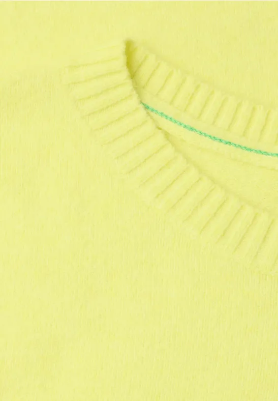 Gros plan sur un pull jaune à col rond en maille douce.