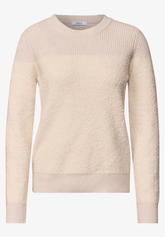 Beiger Damenpullover aus flauschigem Material mit Rundhalsausschnitt und langen Ärmeln.