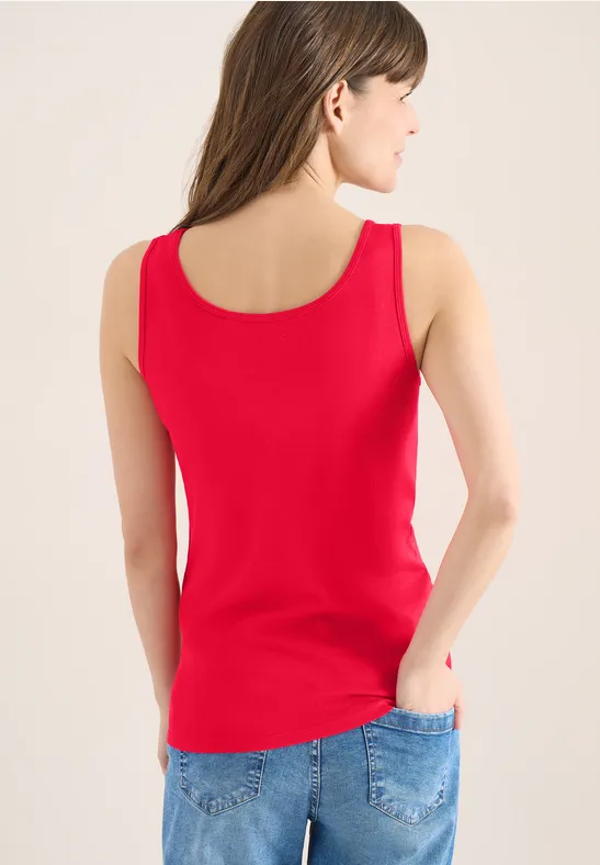 Frau in rotem Tanktop und blauer Jeans von hinten