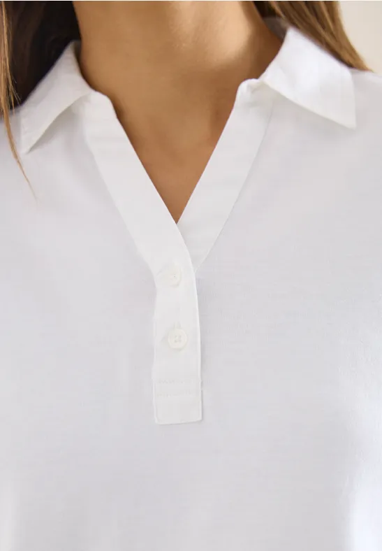 Nahaufnahme eines weißen Poloshirts mit Kragen und kurzer Knopfleiste.
