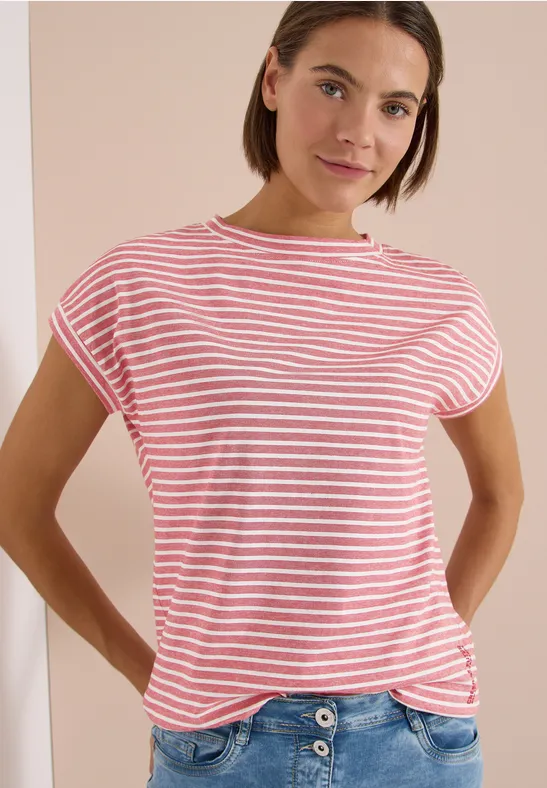Person steht vor beiger Wand und trägt ein rot-weiß gestreiftes T-Shirt mit kurzen Ärmeln.
