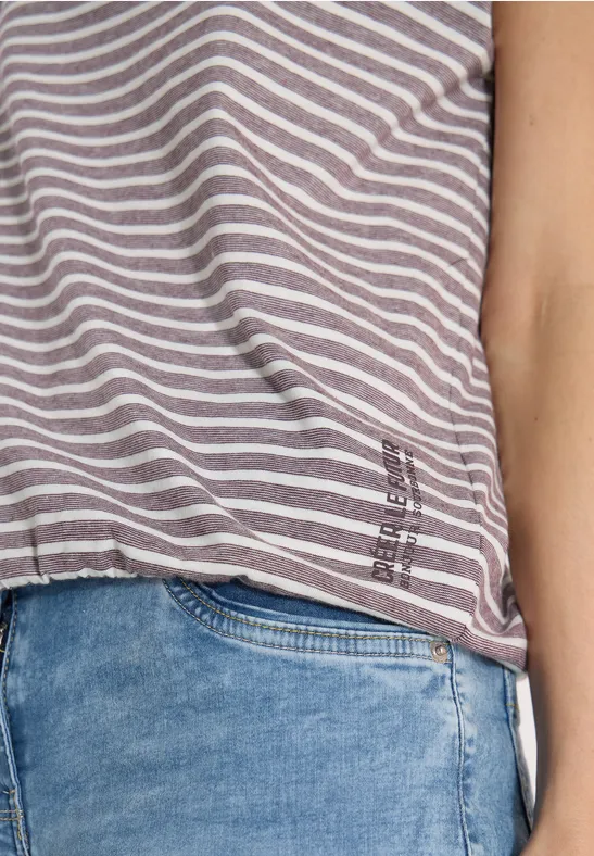 Grau-weiß gestreiftes T-Shirt über blauen Jeans, Ansicht von Schulter bis Hüfte.