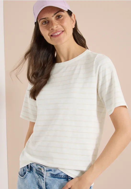 Frau mit weißem, leicht gestreiftem T-Shirt und blauen Jeans