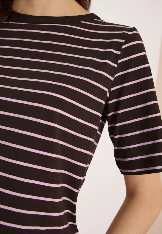 Nahaufnahme einer Person in einem schwarzen T-Shirt mit feinen rosa Querstreifen.